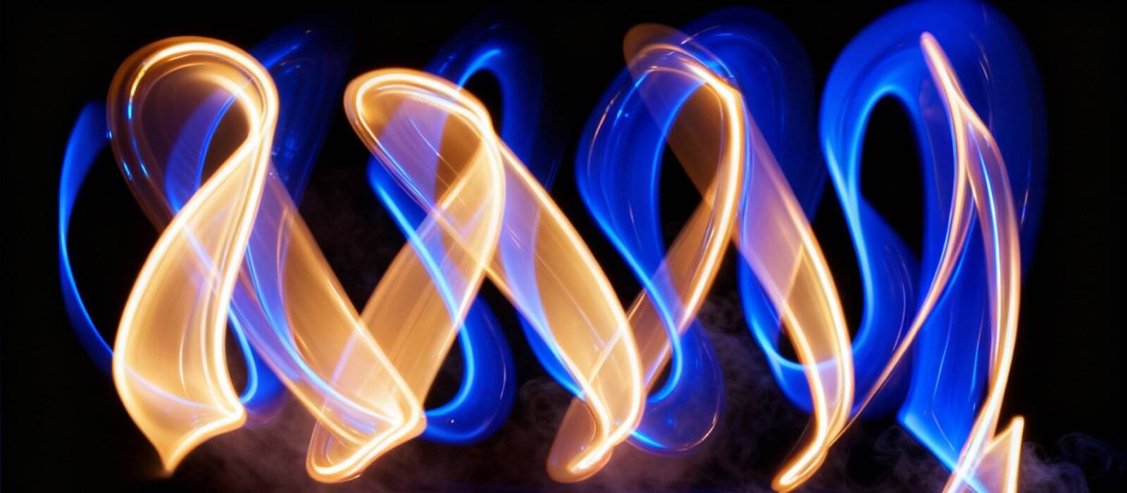 A fire dancer twirls, surrounded by dynamic blue and yellow lights creating a mesmerizing display